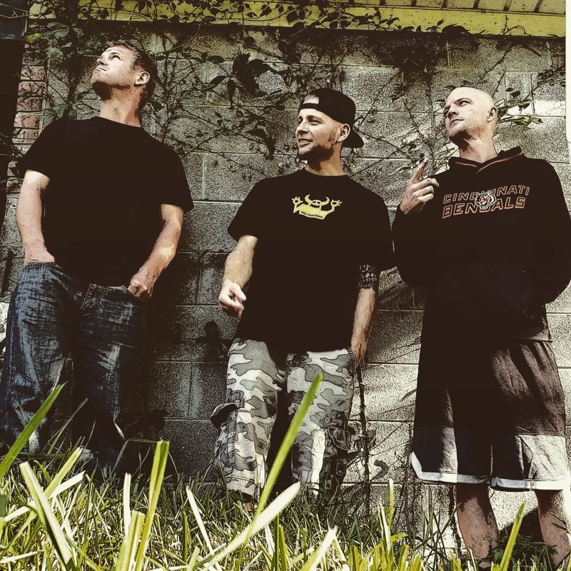 The band against a vine-covered cinder-block wall